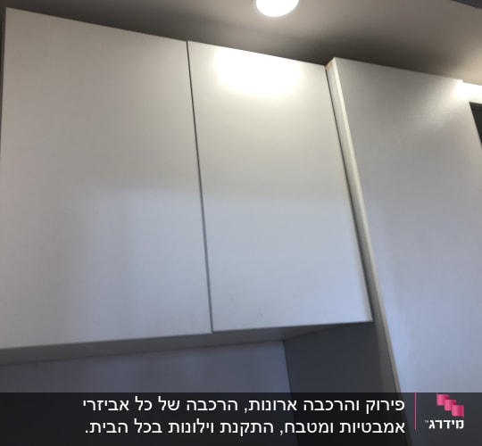 ארונות מטבח לבנים עם תאורה עליונה